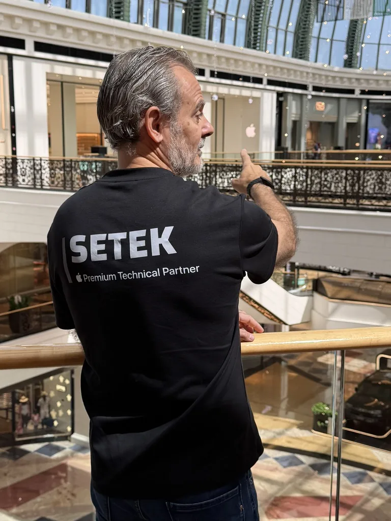 Man in a SETEK Premium Technical Partner shirt pointing at the Apple logo